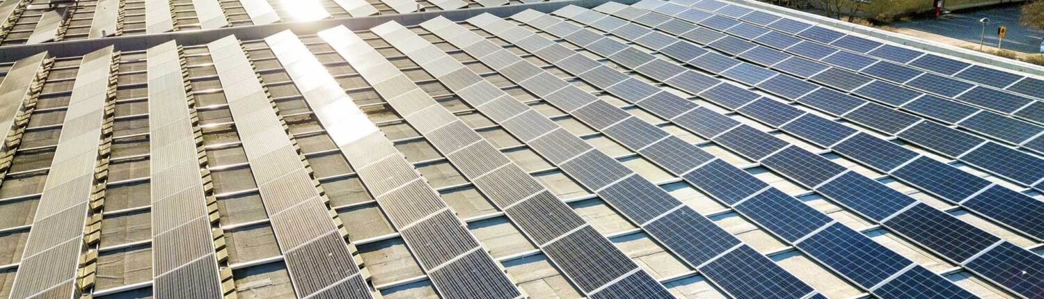 Commercial solar panels with sun shining on them