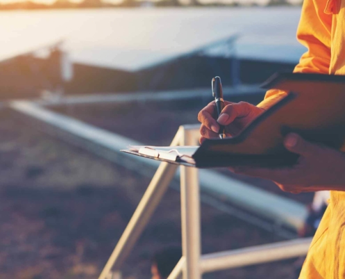 Person writing in a notepad in an empty field